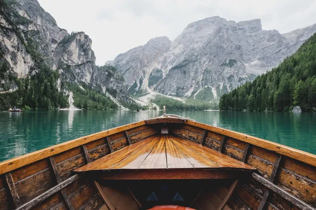 Sebuah perahu di danau dengan pegunungan bersalju dan hutan di kaki bukit 4K wallpaper
