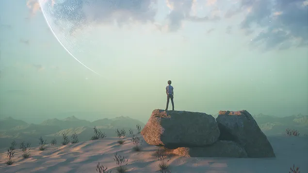 Un niño parado sobre rocas del desierto mirando al cielo descargar