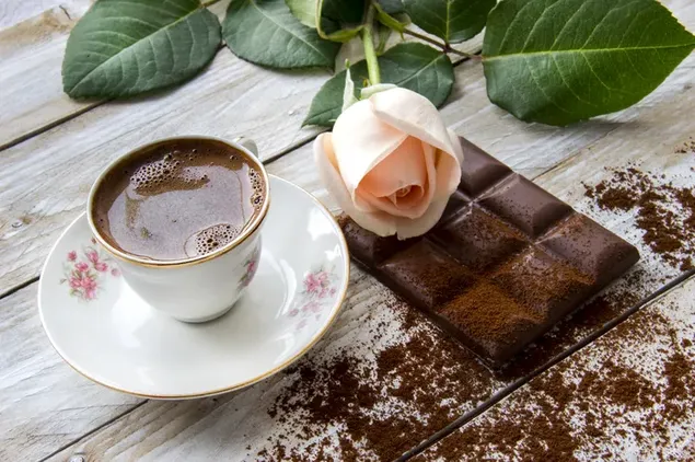 チョコレートバーとクリーム色のバラの花とホットチョコレートのカップ