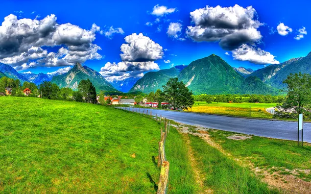 A cute village with a unique mountain view under the clouds and a quiet road through the village 2K wallpaper