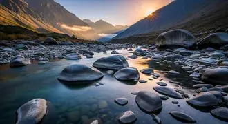 um rio sereno flui sobre pedras lisas em um vale rochoso enquanto o sol nasce acima de montanhas distantes, lancando uma luz quente e reflexos sobre a tranquilidade do local. download