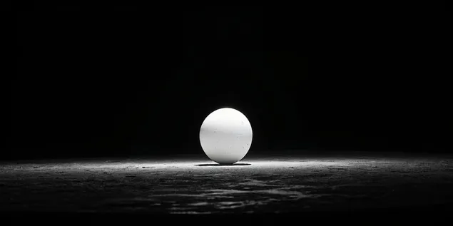 Hình nền Một quả cầu trắng đơn độc nằm trên một bề mặt có kết cấu tối được chiếu sáng bằng ánh sáng dịu nhẹ 4K