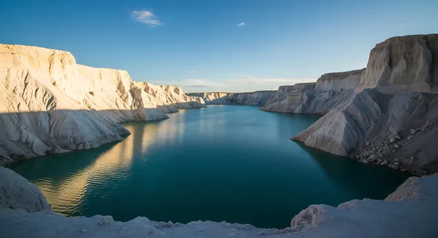 upecatljivo plavo jezero okruzeno je jarko bijelim krecnjackim liticama pod vedrim nebom, stvarajuci dramatican i jedinstven krajolik. preuzmi