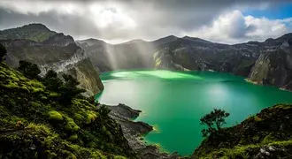 a stunning emerald-green volcanic lake is surrounded by rugged cliffs and lush mossy vegetation, illuminated by peaceful rays breaking through dramati