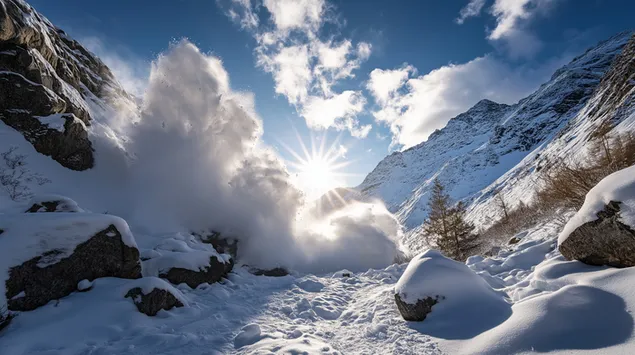 una avalancha iluminada por el sol cae en cascada por una montana rocosa y empinada. descargar
