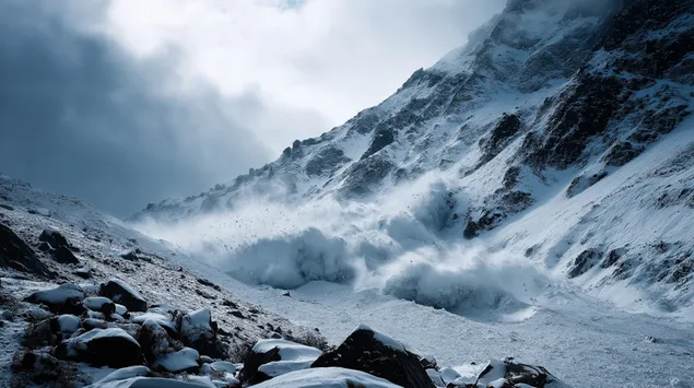 una vista panoramica de una avalancha descendiendo por una montana nevada. descargar