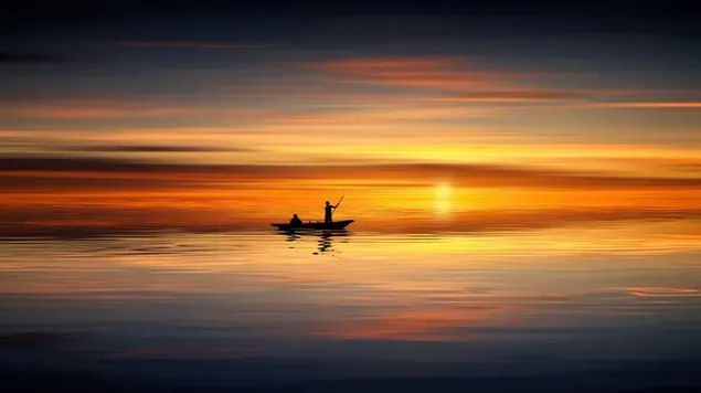 Adembenemend uitzicht van een vissersman die naar de zonsondergang aan zee kijkt download