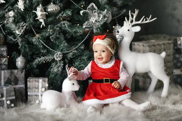 白いクリスマス テーマの背景を持つ赤いドレスで愛らしいサンタ赤ちゃん