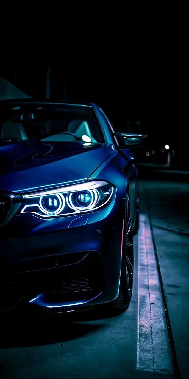 פנסים אגרסיביים בסדאן כחולה ואלגנטית בלילה 2K טפט