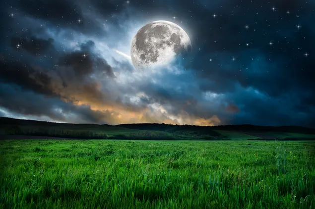 Al final de los campos de hierba, detrás de las montañas, el cielo nublado y la vista de la luna llena que hace la noche descargar