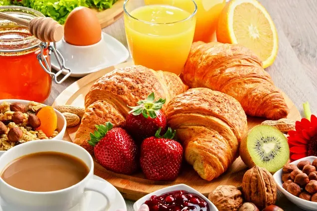 Alimentos dulces y saludables: pan, nueces, frutas, huevo, miel, mermelada, café y jugo