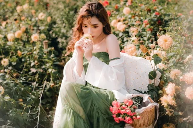 Seductora hermosa mujer asiática recogiendo flores en el jardín 6K fondo de pantalla