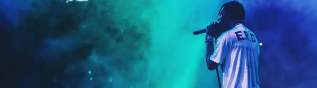 Американскиот рапер и продуцент Тревис Скот пее на сцената со шарена магла и светла 4K тапет