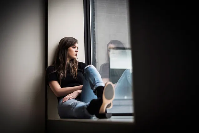Amerikanische Sängerin "Hailee Steinfeld" am Fenster 2K Hintergrundbild