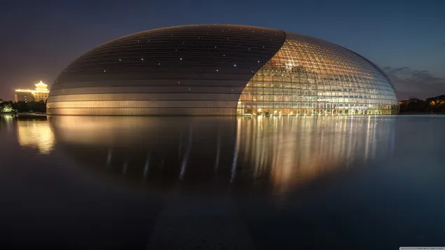 Architekturdesign, das wie ein Ei aussieht, das sich nachts im Wasser spiegelt