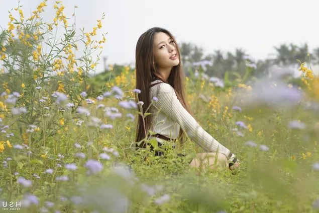 Chica asiática en un campo de flores amarillas y blancas 4K fondo de pantalla