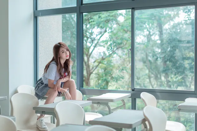 教室の椅子に座っているアジアの女子学生 4K 壁紙