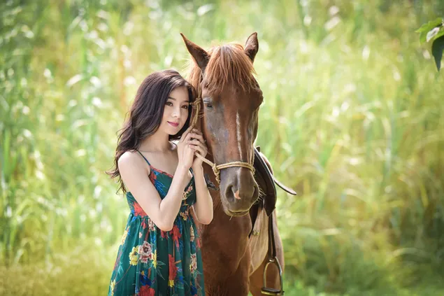 Asian girl with her brown horse plants background
