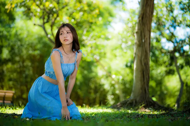 Asiatiese model in blou terno-rok by die park 4K muurpapier