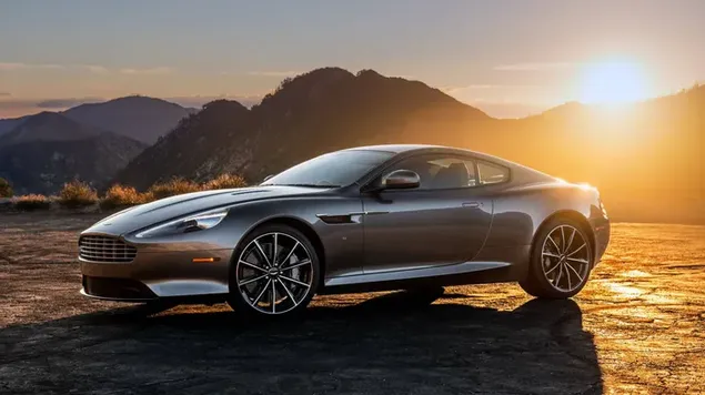 Aston Martin staan ​​geparkeer op die pad in die landskap van daglig wat tussen die berge opkom 4K muurpapier