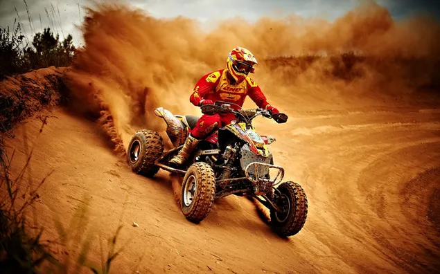 Atv racing on the sand in front of the dust clouds forming behind it 2K wallpaper