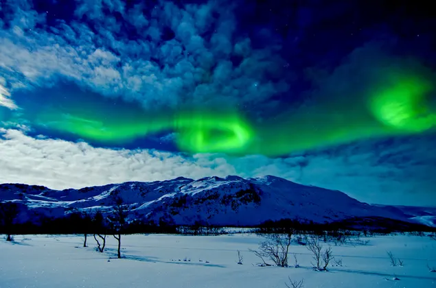 Aurora boreal sobre las montañas de invierno