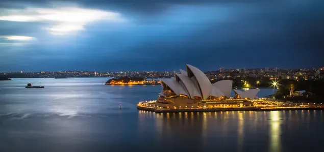街の明かりの下で夜にオーストラリアのシドニー港の素晴らしい空撮 4K 壁紙