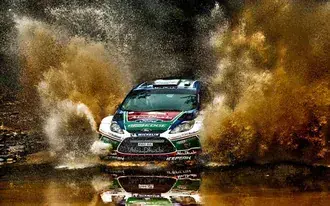 Tapeta Úžasný snímek auta sjíždějícího z bláta do vody v závodech rallye aut 2K