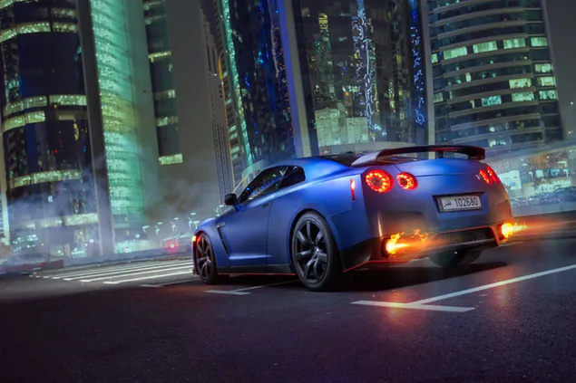 Achteraanzicht van blauwe Nissan GTR in nachtstad download