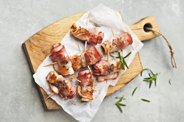 Bacon Roll ups i et skærebræt af træ 4K baggrundsbillede