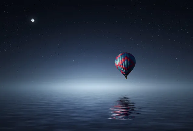 balloon flying over water at night