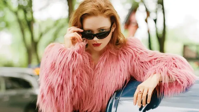 美しいアメリカ人女優セイディ・シンクがピンクの毛皮とサングラスでポーズをとる HD 壁紙
