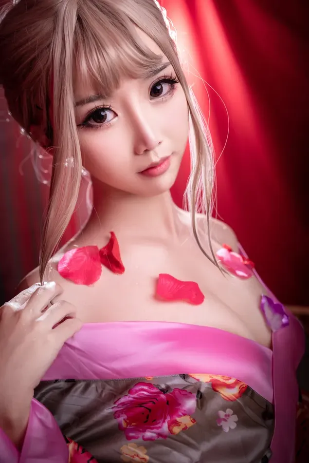 Beautiful asian female model in pink dress with flower petals falling off her shoulders