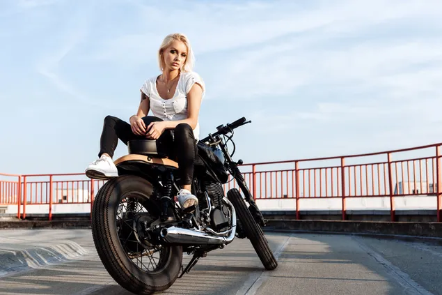 beautiful blonde woman on black motorcycle on asphalt road surrounded by red guards with cloud sky view download
