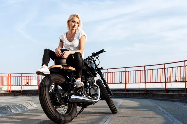 Smuk blond kvinde på sort motorcykel på asfaltvej omgivet af røde vagter med skyhimmeludsigt download