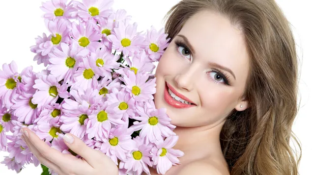 Hermosa modelo con una sonrisa sosteniendo un ramo de flores rosas