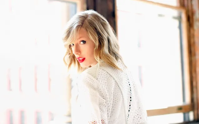 Die schöne Sängerin Taylor Swift posiert vor dem Fenster 2K Hintergrundbild