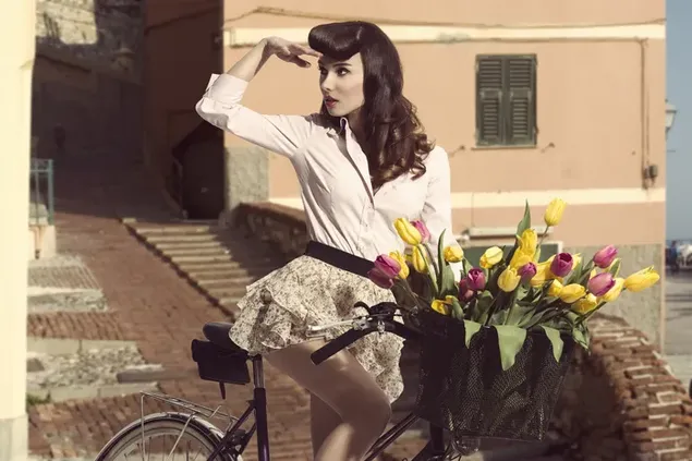 lijepa zena koja vozi bicikl s kosarom cvijeca na starinskoj fotografiji preuzmi