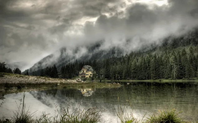 Berge spiegeln sich bei nebligem Wetter im See wider