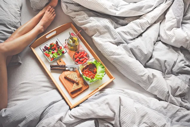 ベッドでの朝食、木製トレイでの野菜サラダとフルーツ