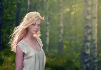 Očaravajući Elle Fanning u šumi 2K pozadina