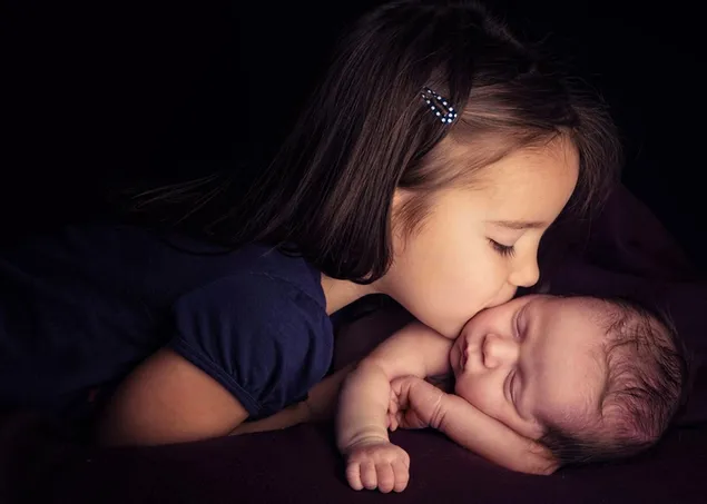 彼女の赤ん坊の兄弟にキスする少女