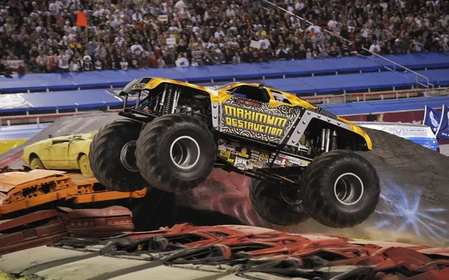 Big-wheeled yellow monster car in crowd on track