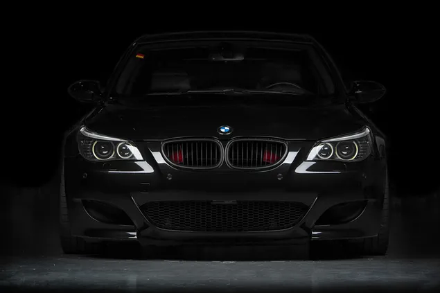 BMW negro con faros encendidos 4K fondo de pantalla