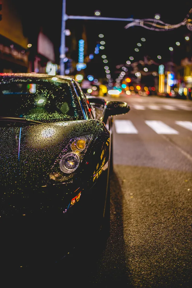Zwarte Lamborghini-auto op de regenachtige dag