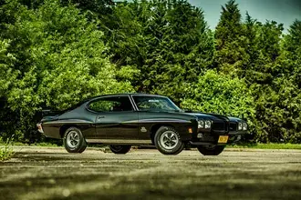 Črni Pontiac GTO Muscle Car z ozadjem zelenih dreves 4K ozadje
