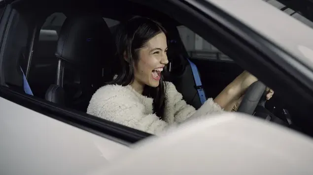 la tenista professional britanica emma raducanu felic pel cotxe esportiu blanc baixada