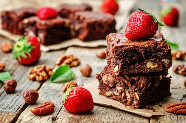 Brownies amb fruits secs i maduixes a taula 4K fons de pantalla