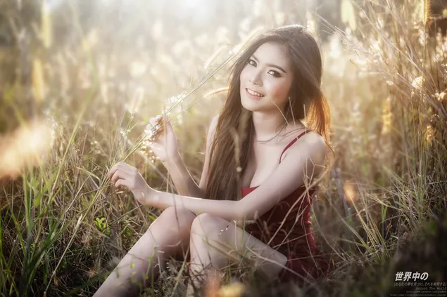 Brunette asian girl in red dress in the field 