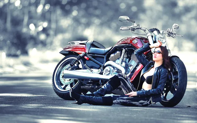 Chica morena sentada al lado de su gran motocicleta